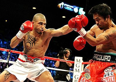 A close-up boxing bout featuring Miguel Cotto (left, in the process of throwing a punch) and Manny Pacquiao.